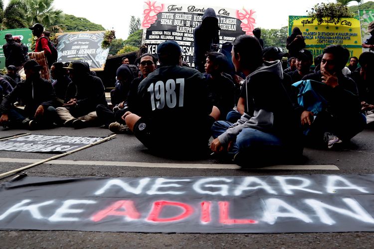 Ratusan suporter Arema FC, Aremania menggelar spanduk melakukan aksi damai menuntut penegakan hukum yang adil terkait Tragedi Kanjuruhan yang menelan 133 korban meninggal di Kota Malang, Kamis (20/10/2022) pagi.