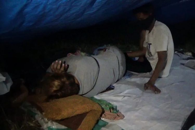 Sukriani terbaring lemah di dalam tenda pengungsian di Majene, Sulawesi Barat. Meski sedang sakit, ia kesulitan mendapatkan obat.