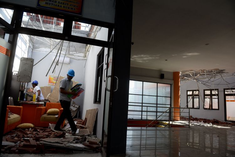 Petugas mengamankan arsip di salah satu ruangan yang rusak akibat gempa di Rumah Sakit Jiwa Mutiara Sukma di Lombok Barat, Nusa Tenggara Barat, Senin (6/8/2018). Gempa bumi bermagnitudo 7 mengguncang Lombok, Minggu (5/8/2018) malam.