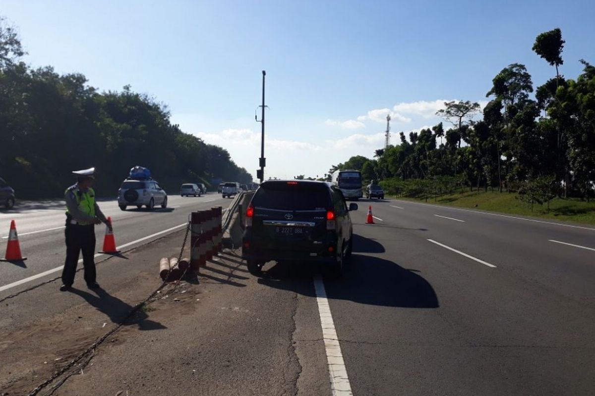 Petugas kepolisian sedang mengatur lalu lintas di jalur contraflow Jalan Tol Jakarta-Cikampek ke arah Jakarta.