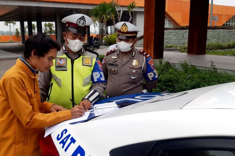 Pengendara motor yang masuk ke jalan tol Jombang - Mojokerto, diminta petugas menandatangani pernyataan setelah dihentikan petugas PJR Polda Jawa Timur, Senin (14/2/2022).