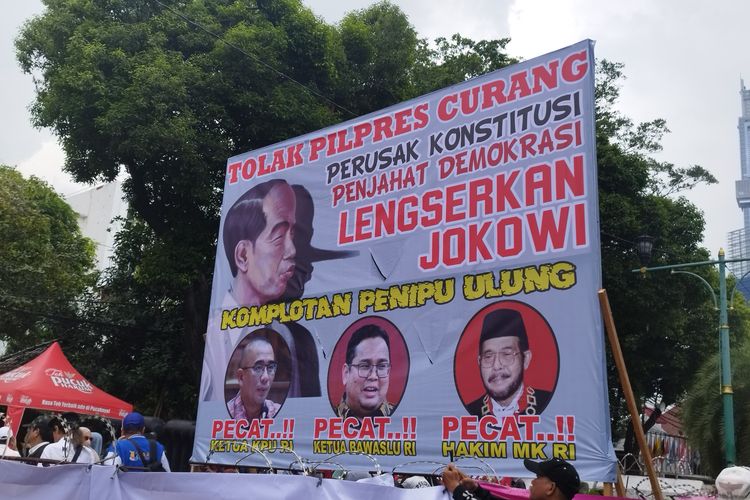 Spanduk lengserkan Jokowi saat aksi di depan kantor Komisi Pemilihan Umum (KPU) RI, Jalan Imam Bonjol, Menteng, Jakarta Pusat, Senin (18/3/2024)