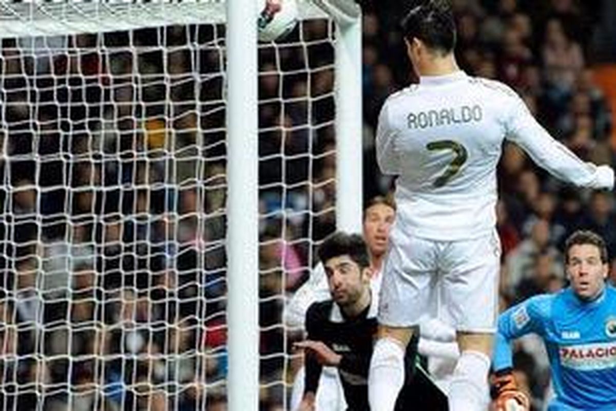 Gelandang Real Madrid, Cristiano Ronaldo, menyundul bola masuk gawang Racing Santander, pada pertandingan Liga BBVA, di Santiago Bernabeu, Sabtu (18/2/2012).