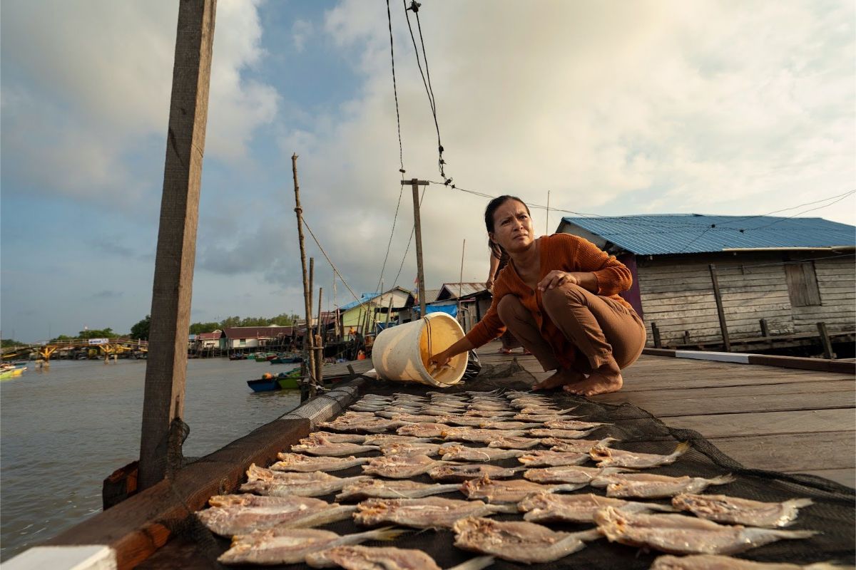 Seorang perempuan menjemur hasil tangkapan ikan di Sepatin, Kalimantan Timur