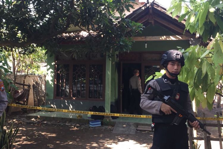 Polisi berjaga-jaga di rumah terduga teroris di Kecamatan Maron Kabupaten Probolinggo saat melakukan penggeledehan. 