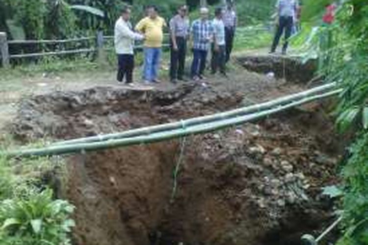 Jembatan ambruk ditinjau aparat desa dan kecamatan di Desa Caringin Wetan, Caringin, Sukabumi, Jawa Barat, Sabtu (14/5/2016). jembatan penghubung antar desa itu ambruk diketahui Sabtu sekitar pukul 03:00 Wib. 