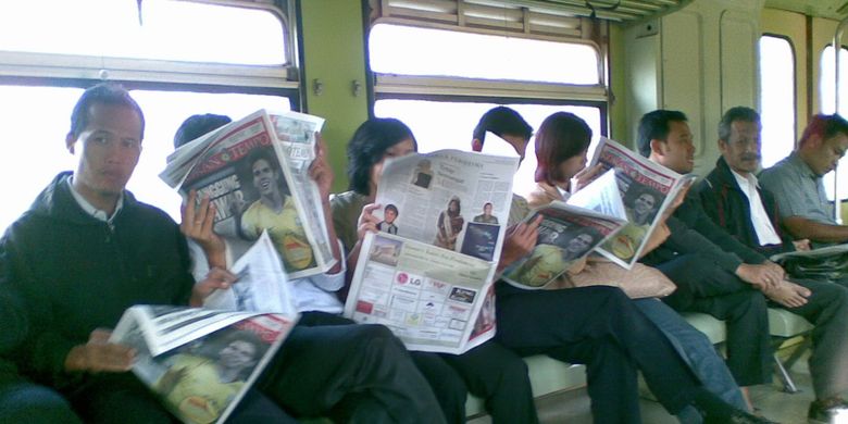 Potret penumpang KA PRameks yang tengah membaca koran di tengah perjalanan kereta