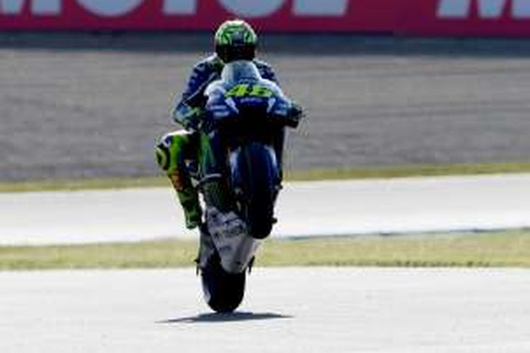 Pebalao Movistar Yamaha MotoGP asal Italia, Valentino Rossi, melakuan wheelie setelah menyelesaikan sesi latihan bebas kedua GP Jepang di Sirkuit Twin Ring Motegi, Jumat (14/10/2016).