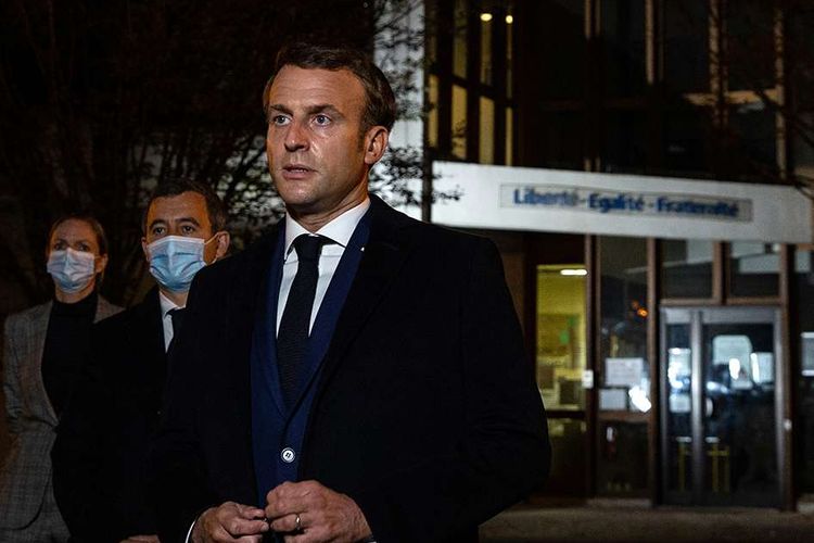 Presiden Perancis Emmanuel Macron (kanan), diapit oleh Menteri Dalam Negeri Prancis Gerald Darmanin (dua kiri), berbicara kepada pers di depan sebuah sekolah menengah di Conflans Saint-Honorine, setelah seorang guru dipenggal oleh penyerang yang ditembak mati oleh polisi, Jumat (16/10/2020). Seorang guru sekolah menengah Paris dibunuh dan dipenggal setelah dilaporkan menunjukkan dan membahas karikatur Nabi Muhammad di kelasnya.