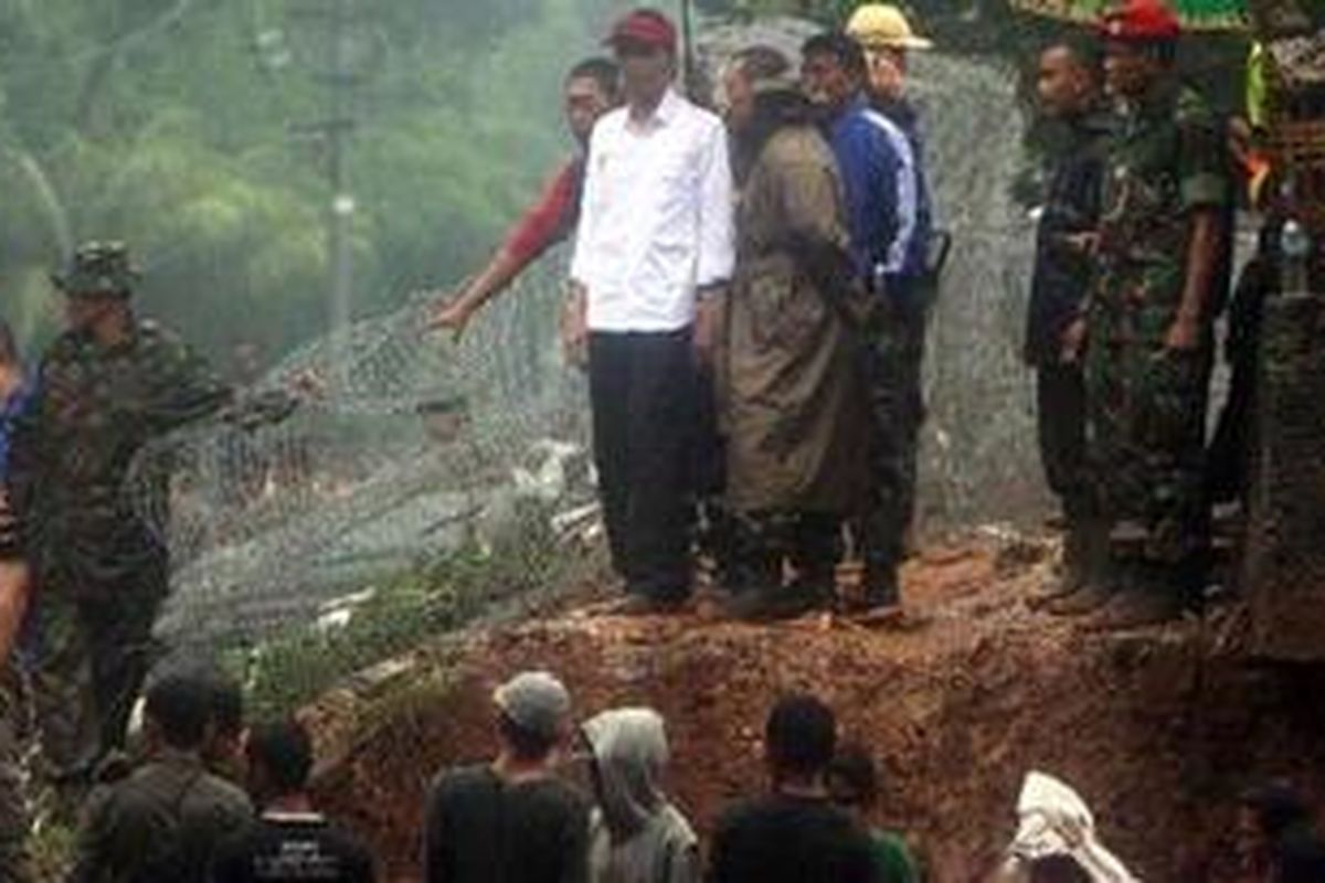 Gubernur DKI Jakarta, Joko Widodo (topi merah) memantau pemasangan tanggul banjir kanal barat di dekat Jalan Latuharhary Jakarta Pusat yang jebol akibat luapan air, Jumat (18/1/2013). Jebolnya tanggul ini menyebabkan banjir menggenangi Jalan MH Thamrin hingga depan Istana Merdeka.  