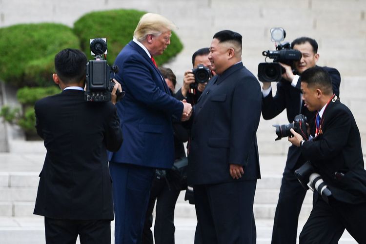 Presiden Amerika Serikat Donald Trump menyalami Pemimpin Korea Utara Kim Jong Un di Zona Demiliterisasi pada Minggu (30/6/2019).