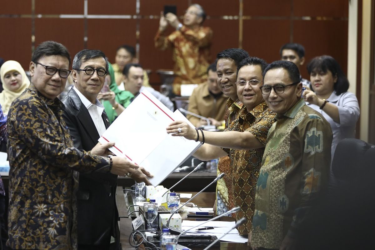 Menteri Dalam Negeri Tjahjo Kumolo (kiri bersama Menteri Hukum dan HAM Yasonna H Laoly (kanan) menyerahkan daftar inventaris masalah saat rapat kerja bersama Badan Legislasi DPR di komplek parlemen, Senayan, Jakarta, Kamis (12/9/2019). Rapat membahas revisi UU MD3 dan perubahan kedua atas UU nomor 30 tahun 2002 tentang KPK. ANTARA FOTO/Tyaga Anandra/Lmo/pd.
