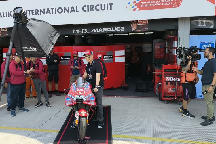 Pengunjung berpose dengan motor balap Marc Marquez di paddock Ducati, MotoGP Indonesia 2026