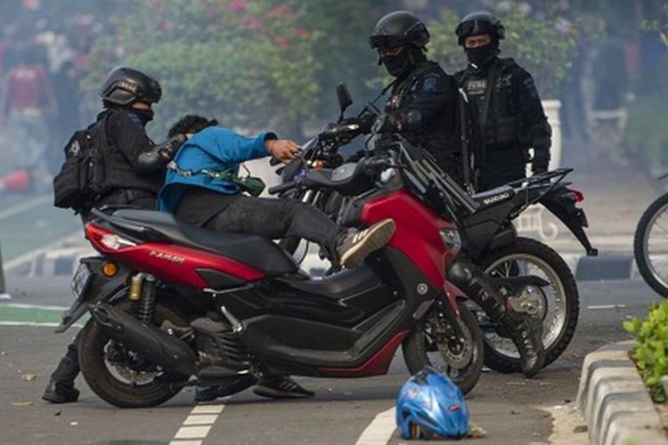 Polisi menahan salah satu pengunjuk rasa saat demo menolak pengesahan Undang-Undang Cipta Kerja berlangsung ricuh di Jalan Medan Merdeka Selatan, Jakarta, Kamis 8 Oktober 2020.