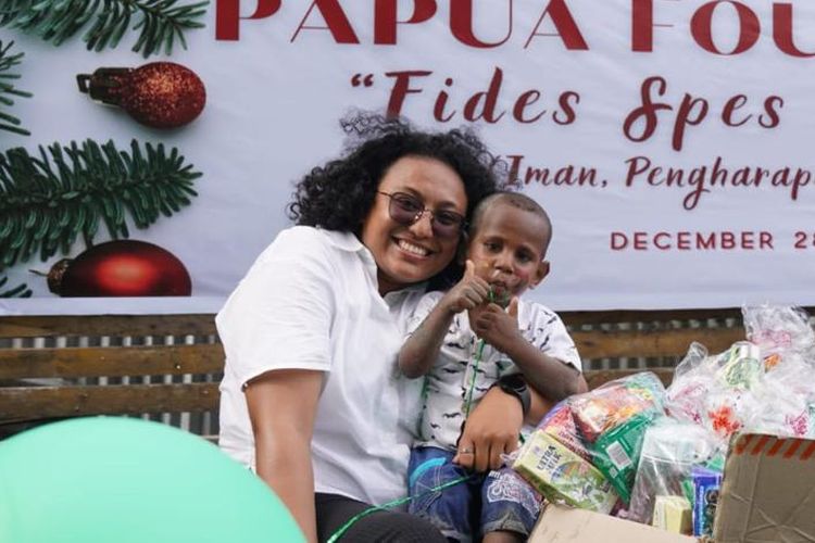 Pendiri Papua Foundation, Patricia Christilotha Mokay, saat memegang seorang anak dalam kegiatan yang dilaksanakan bersama-sama anak di Pantai Hamadi, Kota Jayapura, Papua.