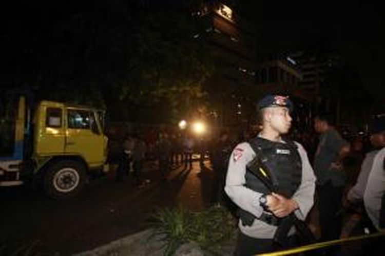 Polisi berjaga-jaga di depan tempat kejadian perkara penembakan seorang anggota polisi persis di depan gedung Komisi Pemberantasan Korupsi, Jalan HR Rasuna Said, Kuningan, Jakarta Selatan, Selasa (10/9/2013). Korban tewas diketahui adalah anggota Provost bernama Bripka Sukardi.