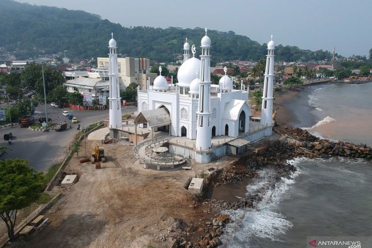 Foto udara kondisi bagian fondasi Masjid Al-Hakim yang terancam abrasi di Pantai Padang, Sumatera Barat, Jumat (19/7/2019). Akibat gelombang tinggi sepekan terakhir, bagian pagar masjid yang yang masih dalam tahap pembangunan tersebut tergerus air laut, Pemkot Padang bersama pemerintah pusat mengantisipasinya dengan membangun dinding pantai menggunakan batu pemecah ombak. 