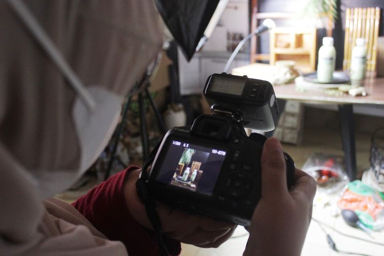 Ani Yuliani (31), seorang ibu rumah tangga di Kabupaten Cianjur, Jawa Barat, memeriksa hasil jepretannya usai memotret produk minuman yang ia tata di atas meja.