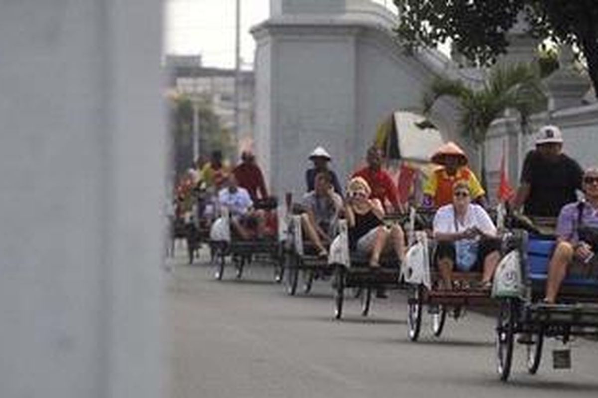 Wisatawan asing melewati Jalan Rotowijayan saat menikmati pemandangan Kota Yogyakarta dari atas becak, Rabu (1/8/2012). Berlangsungnya masa liburan bagi warga Eropa pada pertengahan tahun ini membawa angin segar bagi industri pariwisata di Yogyakarta karena jumlah kunjungan wisatawan domestik turun drastis selama bulan Ramadhan.  
