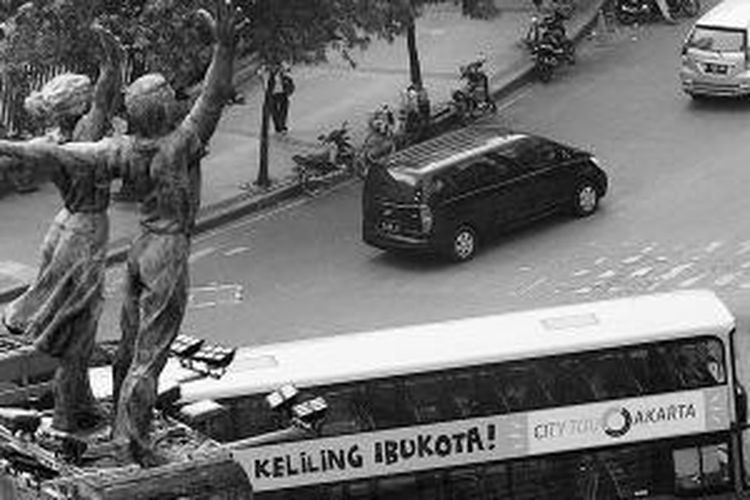 Bus wisata bertingkat melaju di kawasan Bundaran Hotel Indonesia, Jakarta Pusat, Kamis (6/3/2014).