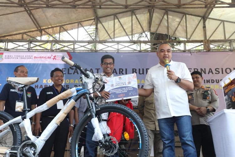 Bupati Tangerang Ahmed Zaki Iskandar (kanan),  membagikan door prize di puncak perayaan Hari Buruh atau Mayday Tingkat Kabupaten Tangerang. Acara yang digelar Puspemkab Tangerang pada Sabtu (6/5/23) diikuti oleh ribuan buruh.
