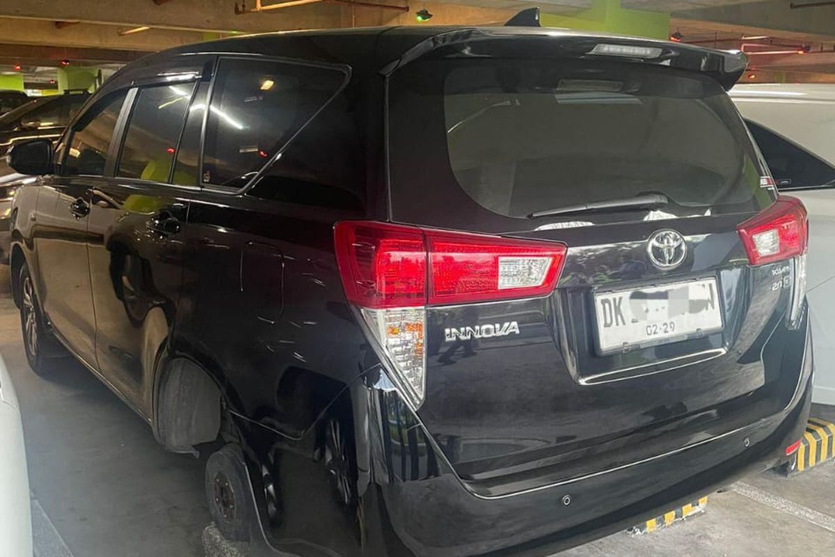 mobil Toyota Innova kehilangan ban dan pelek di Parkiran lantai III kawasan Bandara Internasional I Gusti Ngurah Rai, Kabupaten Badung, Provinsi Bali, pada Selasa (15/7/2025).