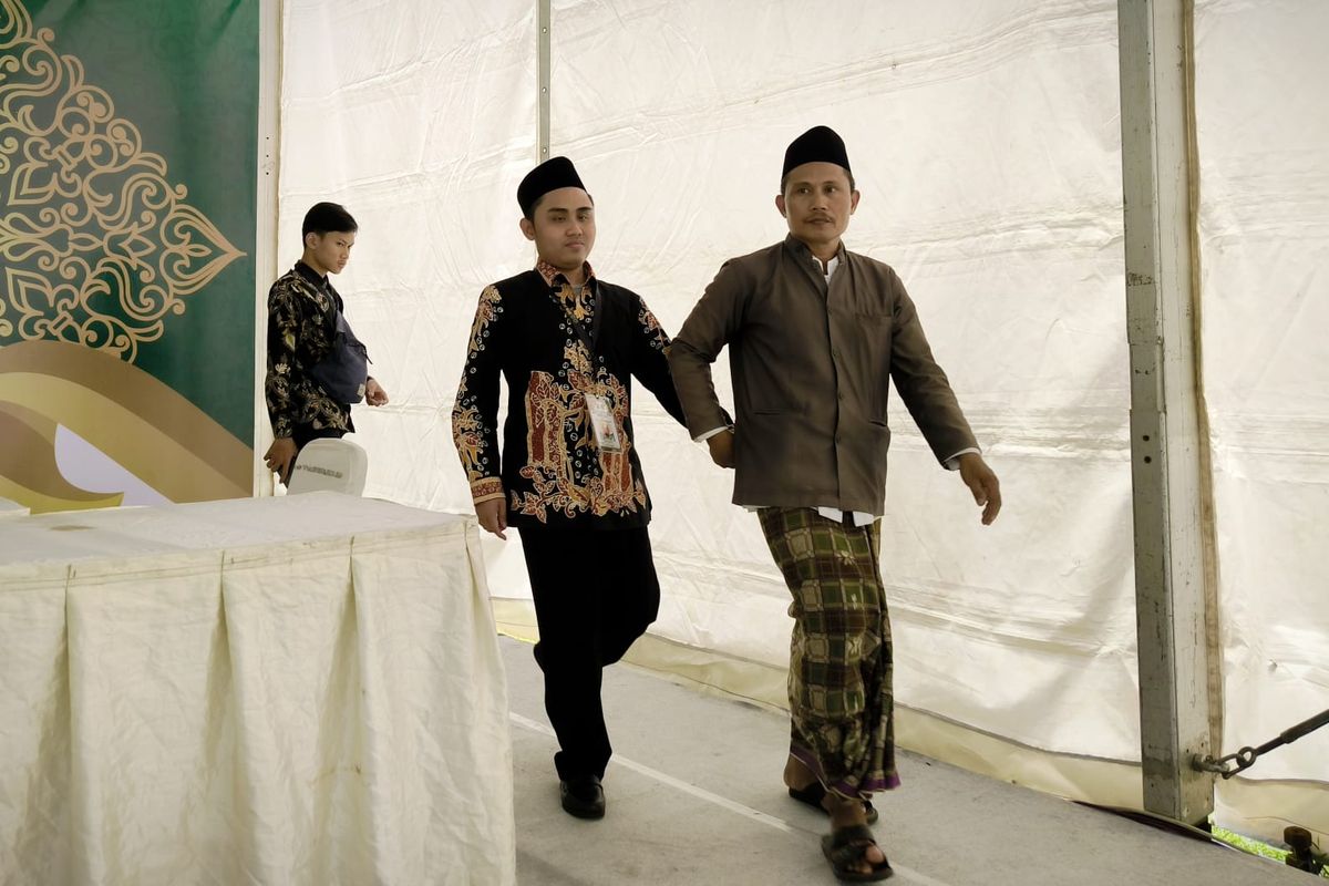 Musaddad finalis lomba MTQ Jatim digandeng sang ayah usai masuk babak final di Pesantren Al Qodiri Jember, Jumat (19/9/2025).