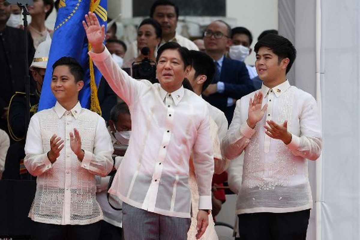 Presiden baru Filipina Ferdinand Marcos Jr (tengah) melambaikan tangan kepada para pendukungnya bersama putra-putranya, setelah dilantik sebagai pemimpin baru negara itu, dalam upacara peresmian di Museum Nasional di Manila pada 30 Juni 2022.