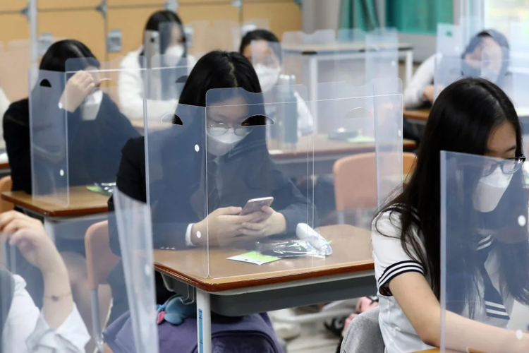 Ilustrasi anak sekolah di Korea Selatan yang sedang menggunakan handphone di ruang kelas. 