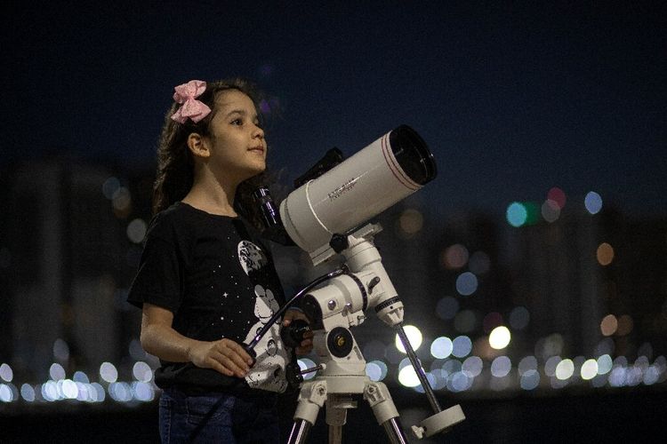 Nicole Oliveira (8 tahun), astronom cilik berpose dengan teleskopnya in Fortaleza, Brasil. Gadis kecil ini dijuluki sebagai astronom termuda di dunia.
