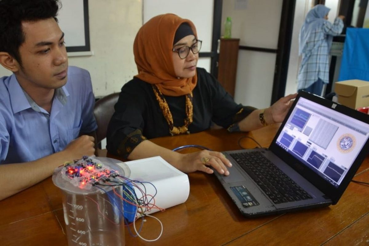 Dr Suryani Dyah Astuti, MSi bersama Surya, salah satu mahasiswanya, sedang mendemonstrasikan kan E-Nose di Laboratorium Biofisika FST Unair Kampus C. 