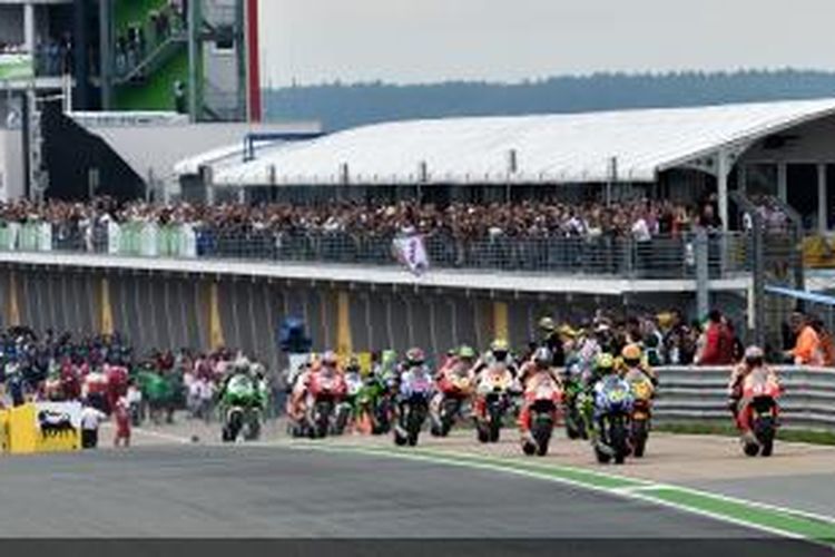 Para pebalap MotoGP keluar dari pit lane Sachsenring setelah melakukan start GP Jerman, Minggu (13/7/2014).