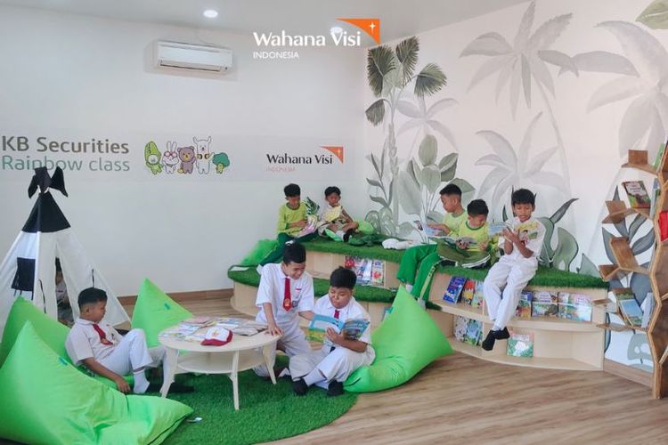 Para siswa sekolah dasar tampak asyik membaca buku di perpustakaan yang telah direnovasi. 