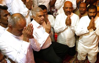 Perdana Menteri baru Sri Lanka Ranil Wickremesinghe, kedua kiri, mengambil bagian dalam perayaan keagamaan di sebuah kuil di Kolombo, Sri Lanka, Kamis, 12 Mei 2022.