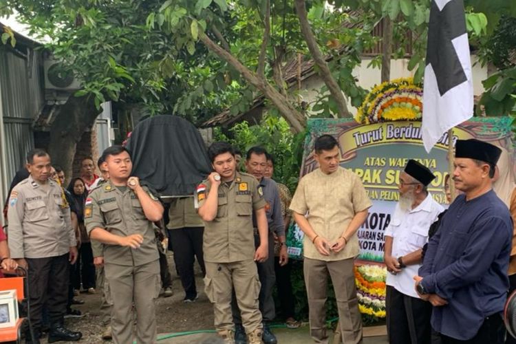 Wali Kota Madiun, Maidi (baju hitam), memimpin jalannya upacara pemakaman Sugiyono (60), anggota Satlinmas Kota Madiun yang meninggal saat menjalankan tugas di TPS 06, Kelurahan Ngegong, Kecamatan Manguharjo, Kota Madiun, Jawa Timur, Rabu (14/2/2024) petang.