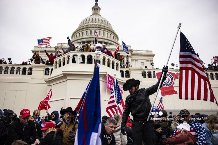 Massa pendukung Presiden Amerika Serikat (AS) Donald Trump menyerbu Gedung Capitol di Washington DC, 6 Januari 2021. Pendukung Trump berkumpul di ibu kota untuk menghentikan Kongres AS mengesahkan kemenangan Joe Biden.