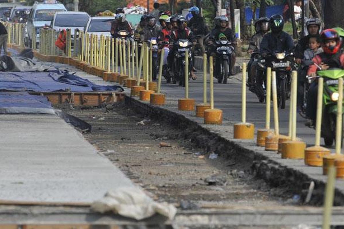 Pengerjaan proyek jalan beton di Jalan Mayjend DI Panjaitan, Jakarta Timur, Minggu (3/6/2012). Jalan dibeton karena konstruksi jalan lama dari aspal mudah rusak akibat beban berat kendaraan yang melintas. 