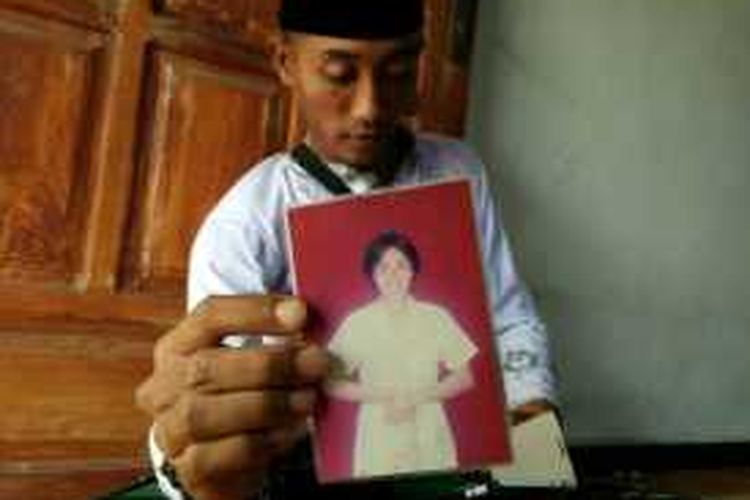 Khairul Anam, anak pertama Emi Rusmiyati, tenaga kerja wanita asal Desa SUmberejo Kecamatan Bangorejo Kabupaten Banyuwangi yang meninggal di Taiwan menunjukkan foto ibunya. Menurutnya, ibunya sangat ingin melihat dia menggunakan seragam tentara
