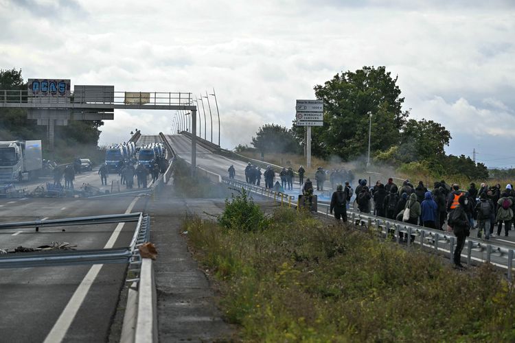 Petugas dari subdivisi Mobile Gendarmerie (GM) (belakang dari kiri) menyingkirkan blokade yang dibuat oleh para pengunjuk rasa di viaduk Cadix sebagai bagian dari demo Perancis bertajuk Block Everything di Caen, Perancis barat laut, Rabu (10/9/2025). 