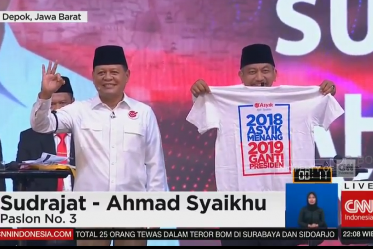 Pasangan calon gubernur dan wakil gubernur nomor urut 3 Sudrajat dan Ahmad Syaikhu membawa kaus bertuliskan 2018 Asyik Menang, 2019 Ganti Presiden. Aksi ini membuat situasi debat publik kedua Pilgub Jabar di Balairung Universitas Indonesia Depok, semakin panas, Senin (14/5/2018).