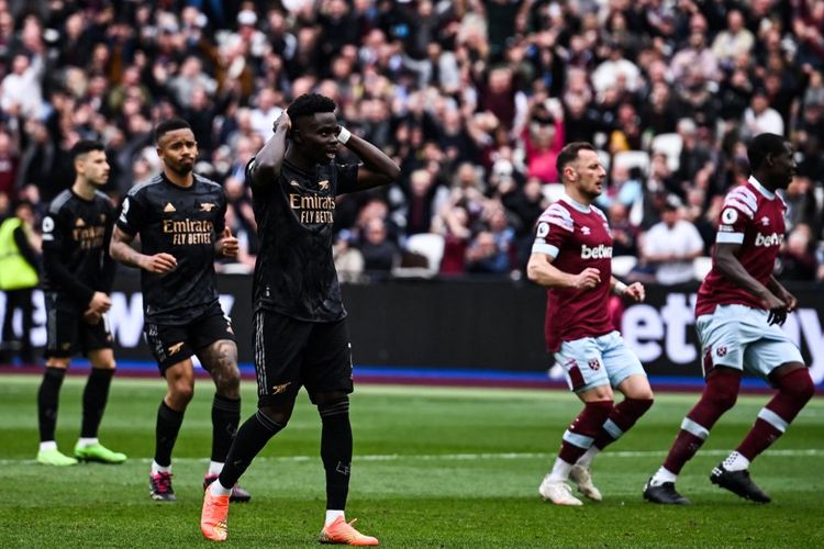 Winger Arsenal Bukayo Saka (tengah) kecewa setelah gagal mengeksekusi penalti ke gawang West Ham United pada laga pekan ke-31 Liga Inggris 2022-2023 di Stadion Olimpiade London, Minggu (16/4/2023) malam WIB. Artikel ini memuat hasil Liga Inggris 2022-2023. 