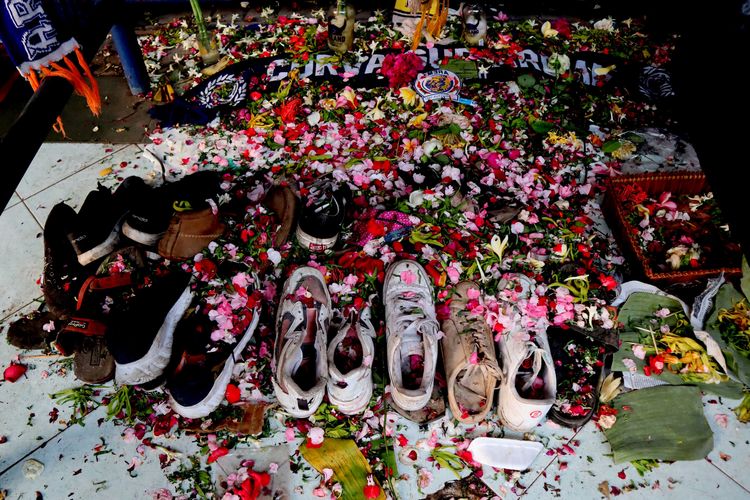 Sepatu milik korban ditaburi diantara taburan bunga pasca tragedi yang terjadi pada pekan ke-11 Liga 1 2022-2023 seusai pertandingan bertajuk Derbi Jawa Timur, Arema FC melawan Persebaya Surabaya di Monumen Singa Tegar Stadion Kanjuruhan Kepanjen, Kabupaten Malang, Selasa (4/10/2022) sore.