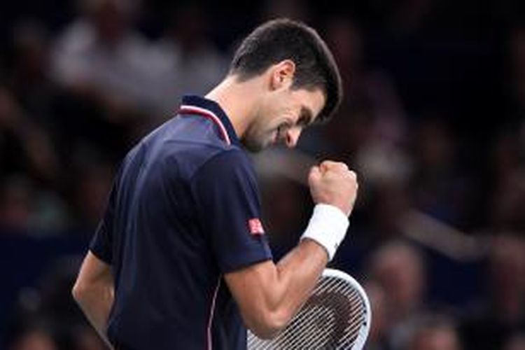Petenis Serbia, Novak Djokovic, bereaksi setelah mendapatkan poin ketika menghadapi petenis Kanada, Milos Raonic, pada laga final Paris Masters di Bercy, Minggu (2/11/2014).