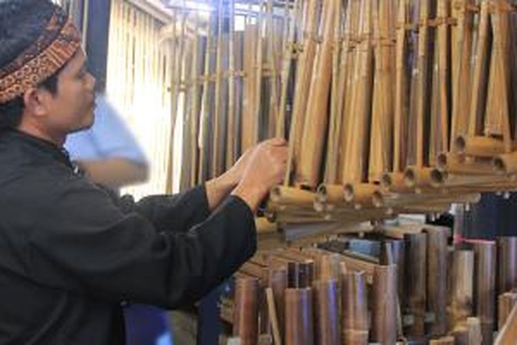 Pendi sedang memainkan angklung di Sanggar Angklung miliknya