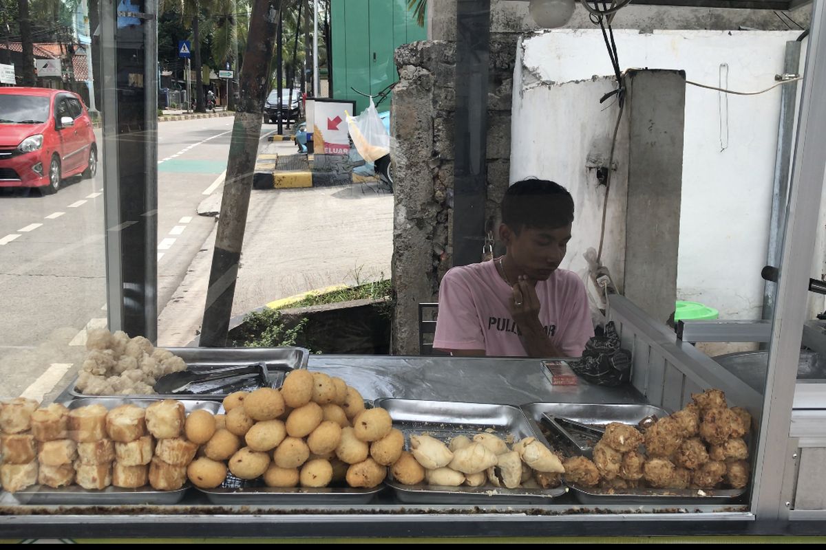 Acep (20), pedagang gorengan di Jalan Taman Margasatwa Ragunan, Jakarta Selatan sedang berdagang pada Minggu (3/1/2021) siang.
