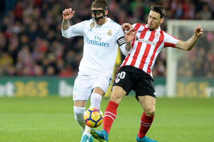 Sergio Ramos dan Aritz Aduriz berebut bola pada pertandingan La Liga antara Athletic Bilbao dan Real Madrid di San Mames, Sabtu (2/12/2017).
