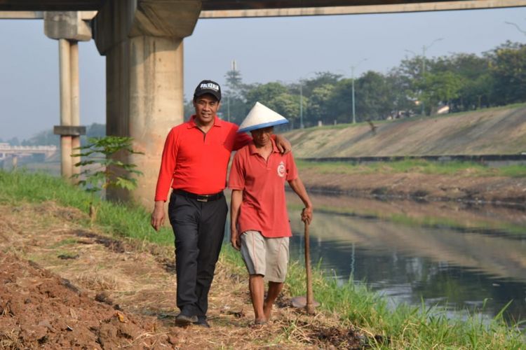 Menteri Pertanian Andi Amran Sulaiman bersama seorang petani yang menggarap bantaran Kanal Banjir Timur, Sabtu (14/7/2018)