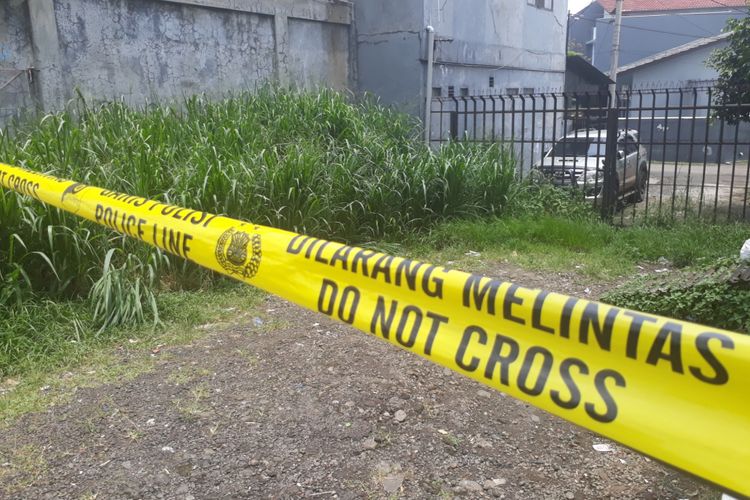 Polisi memasang police line (garis polisi) di lokasi temuan jasad wanita tanpa identitas di area Perumahan Cibinong Griya Asri, Kecamatan Cibinong, Kabupaten Bogor, Senin (19/3/2018).