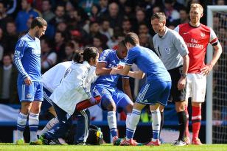 Penyerang Chelsea Samuel Eto'o (tengah) dibantu tim medis karena mengalami cedera, pada pertandingan Premier League melawan Arsenal, di Stamford Bridge, Sabtu (22/3/2014).