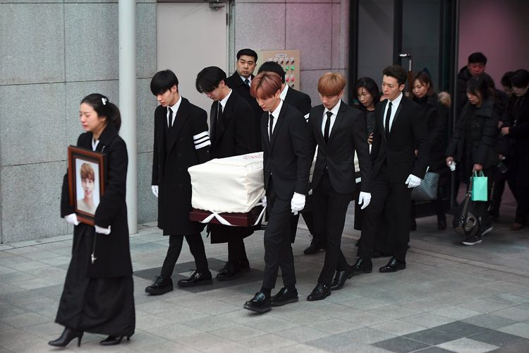 Kakak Jonghyun (membawa foto) berjalan di depan pada pelepasan jenazah member boyband SHINee tersebut menuju tempat pemakaman dari Asan Hospital, Seoul, Kamis (21/12/2017). Para member SHINee dan Super Junior mengangkat peti Jonghyun menuju mobil jenazah.
